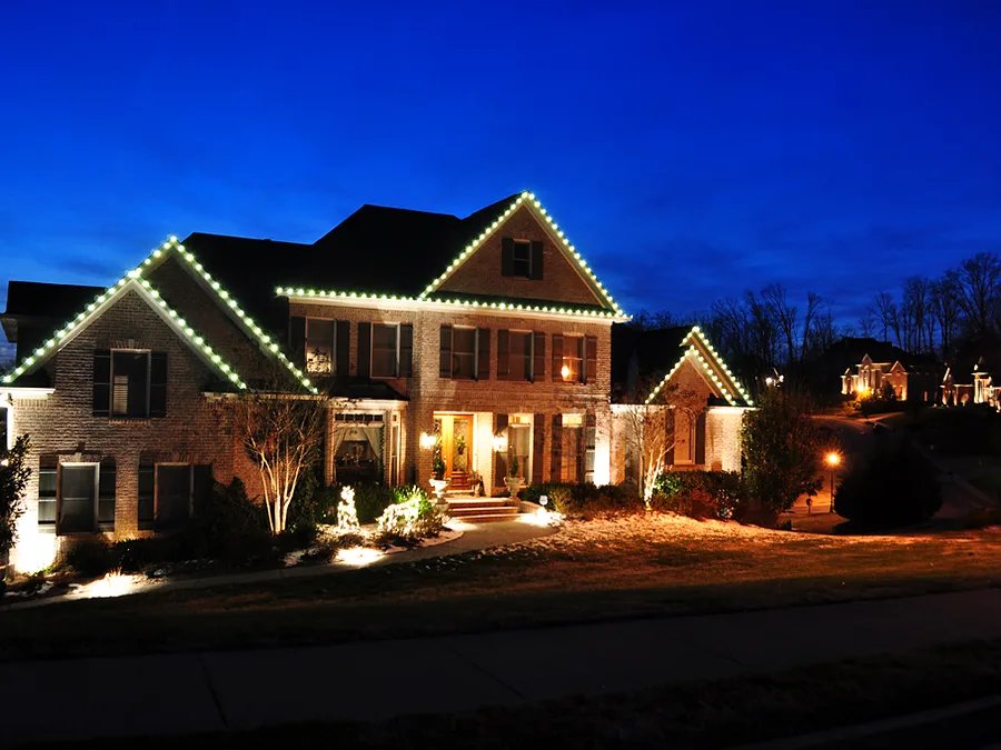 Home photographed at blue hour with crisp white roofline lighting and lit walkway